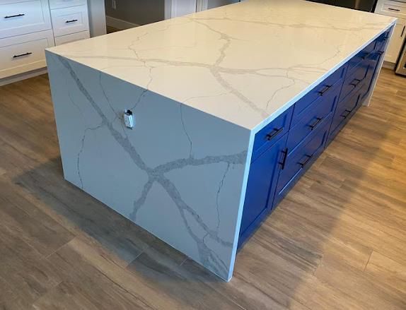 Calacatta quartz waterfall island on navy cabinetry — an AZ Elite Granite install in the Phoenix valley